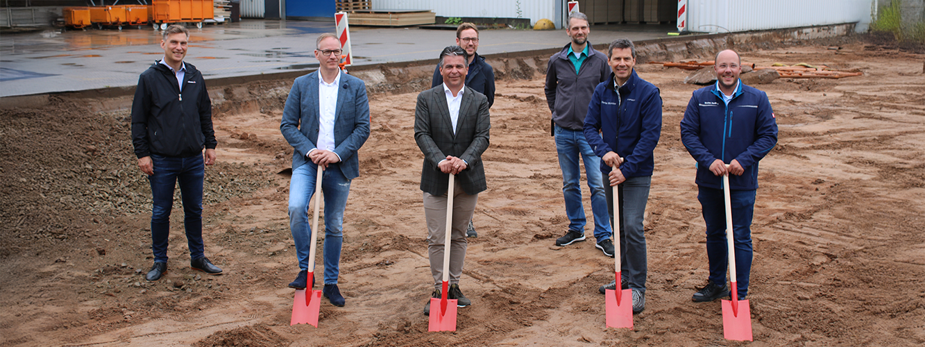 Die Geschäftsführung von pronorm und weitere Mitarbeitende beim Spatenstich auf der Baustelle für die neuen Halle