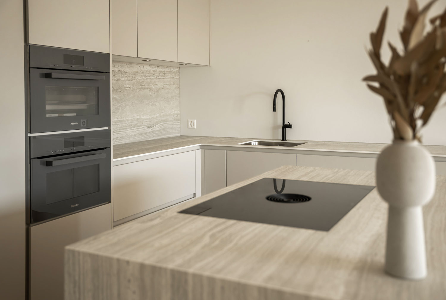 Moderne Einbauküche mit Küchenbeleuchtung und marmorierter Arbeitsplatte