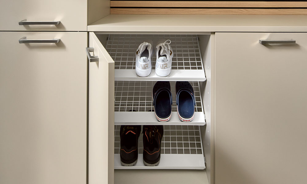 Ruimtebesparende schoenenopslag geïntegreerd in een kast.