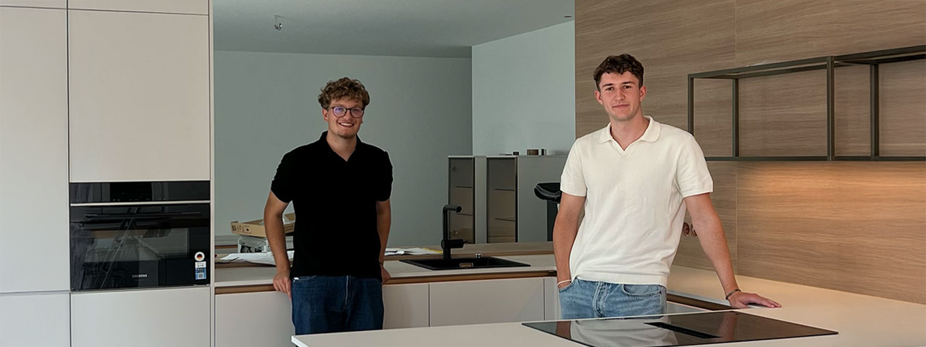 Two pronorm apprentices installing a modern end-customer kitchen as part of a trainee project