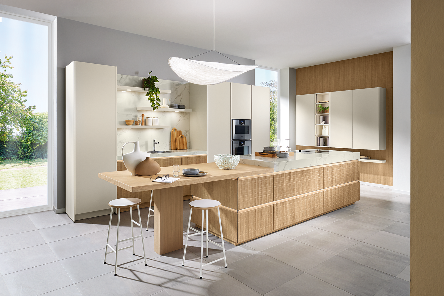 Lichte leefkeuken in Boho-design met greeploos kookeiland, wolwitte kasten en een geïntegreerde wandoplossing in eikenstructuur