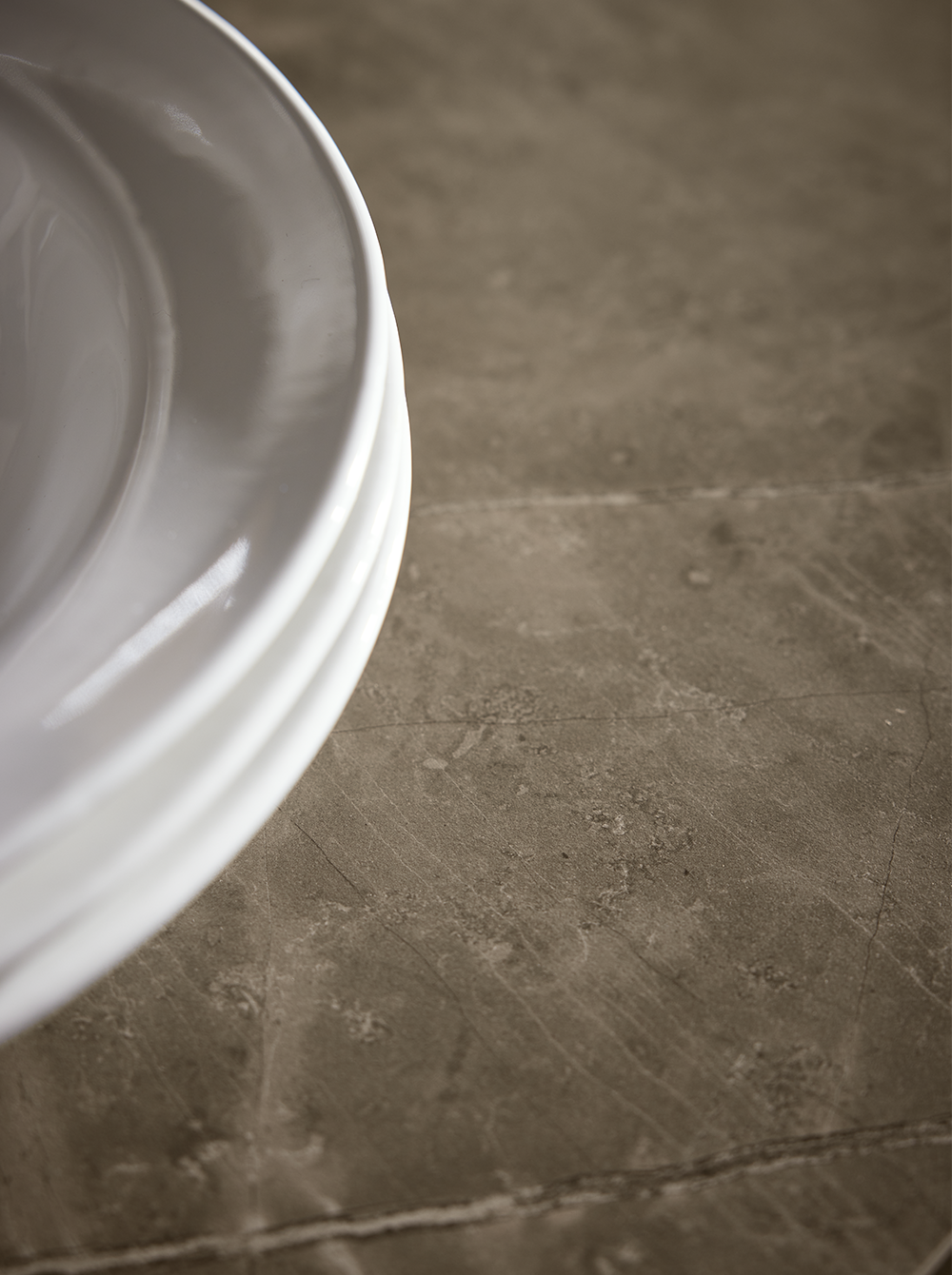 Natural-look countertop in textured stone finish – detail from a cozy farmhouse kitchen