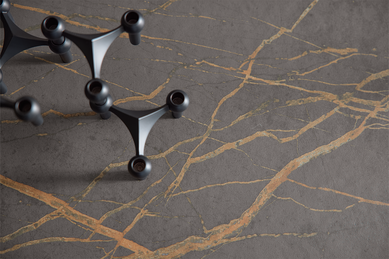 Detailansicht einer hochwertigen pronorm Arbeitsplatte in dunkler Steinoptik mit markanter goldener Aderung – stilvolles Küchendesign.