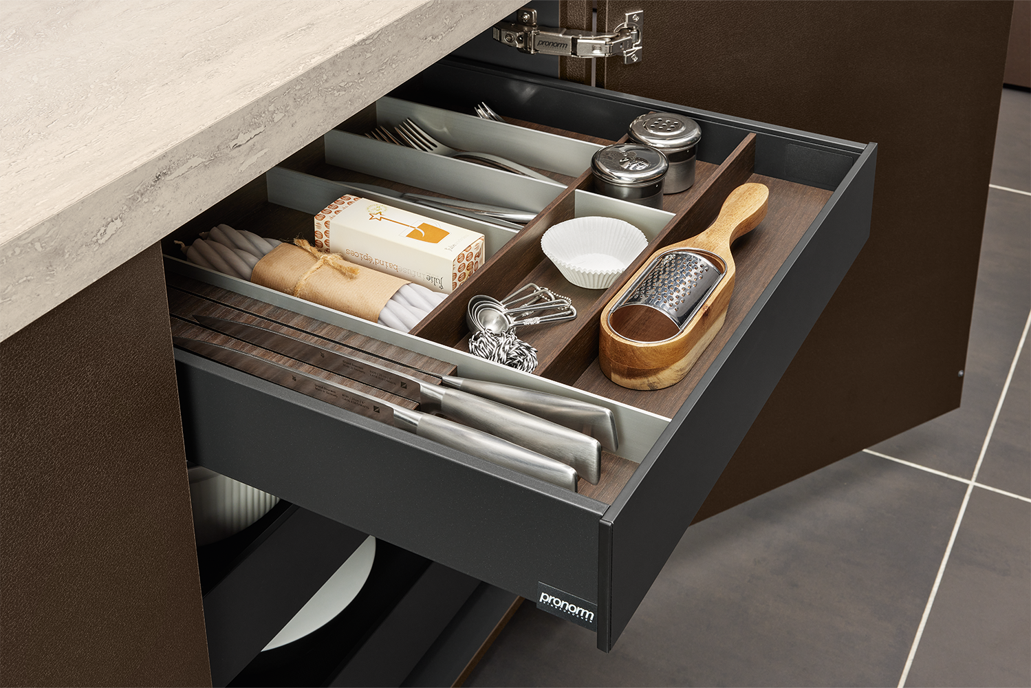 Detailed view of cutlery insert with dark wood dividers and functional layout, from pronorm’s proTech X organisation system