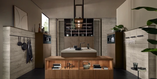 Vooraanzicht van open keuken met wand in steenlook, glazenhouders en notenhouten legplanken van pronorm