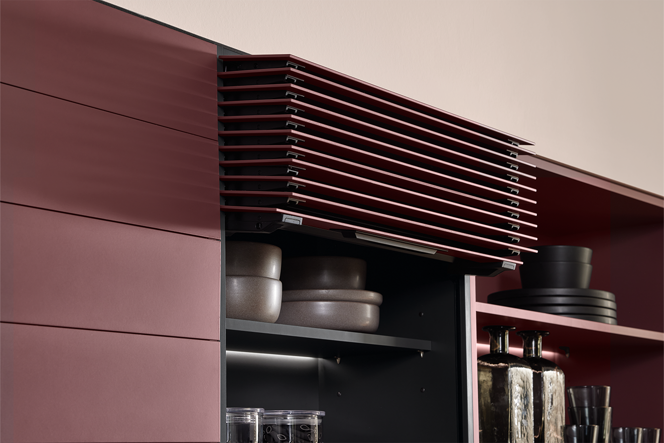 Handleless Flipdoors in burgundy design, opened to display integrated kitchen shelving