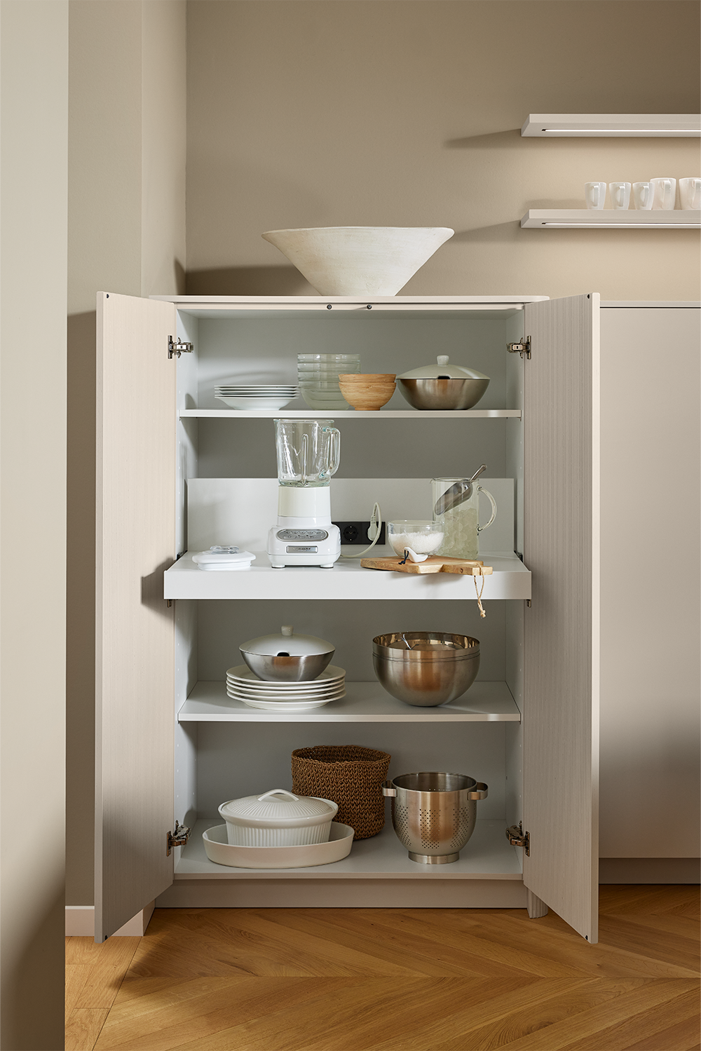 Interior view of an open kitchen cabinet with tray shelves – harmoniously integrated into the living space.