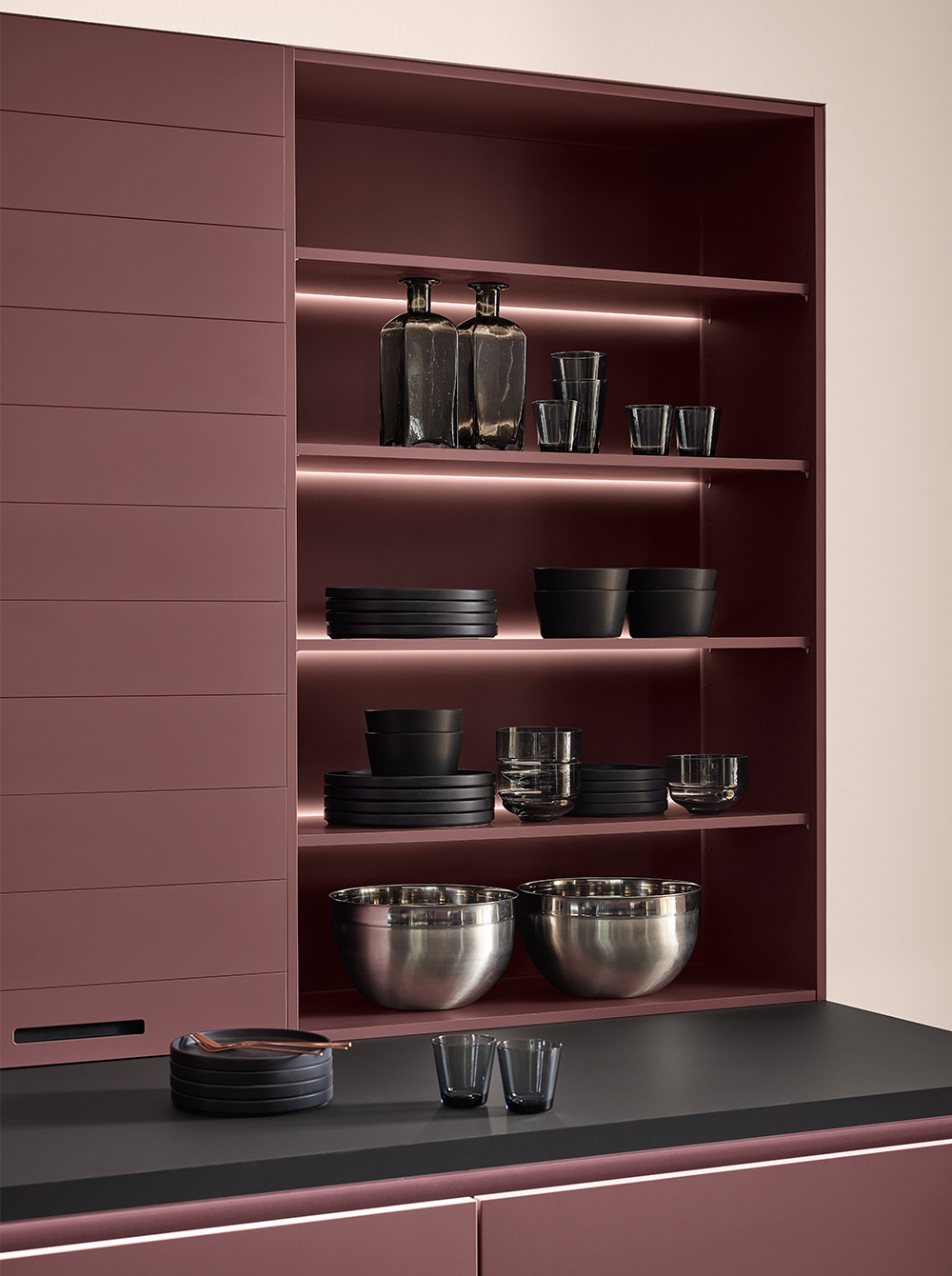 Burgundy kitchen shelving unit with built-in LED lighting and elegant dishware on display