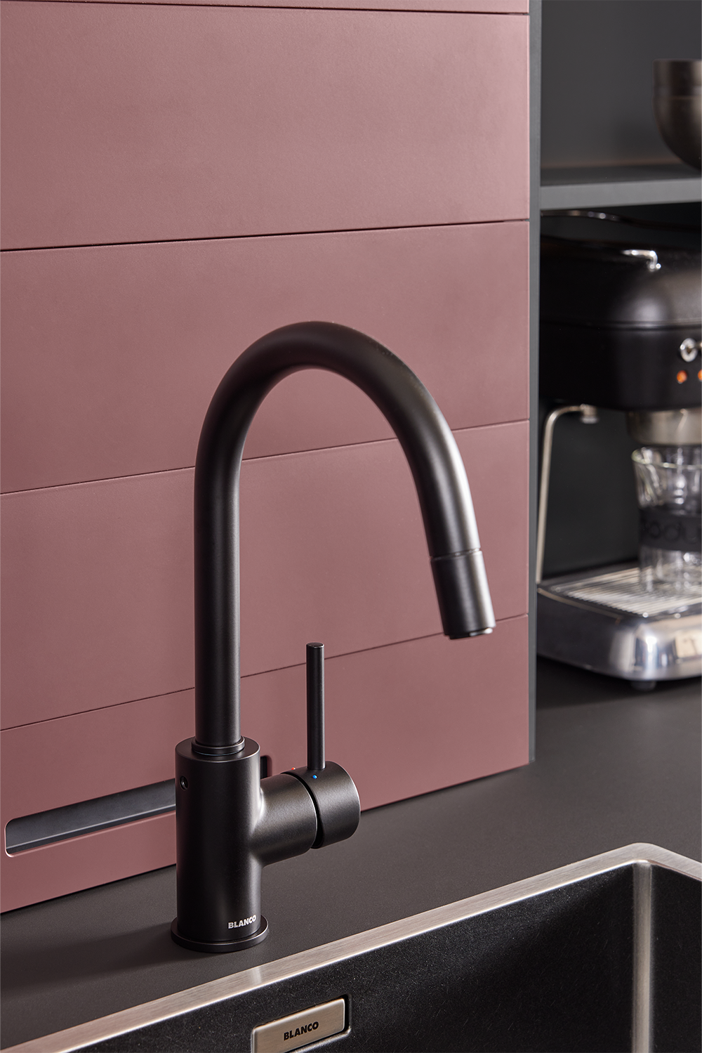 Schwarze Design-Armatur von Blanco in moderner pronorm Küche mit mattem Spülbecken und roten Fronten