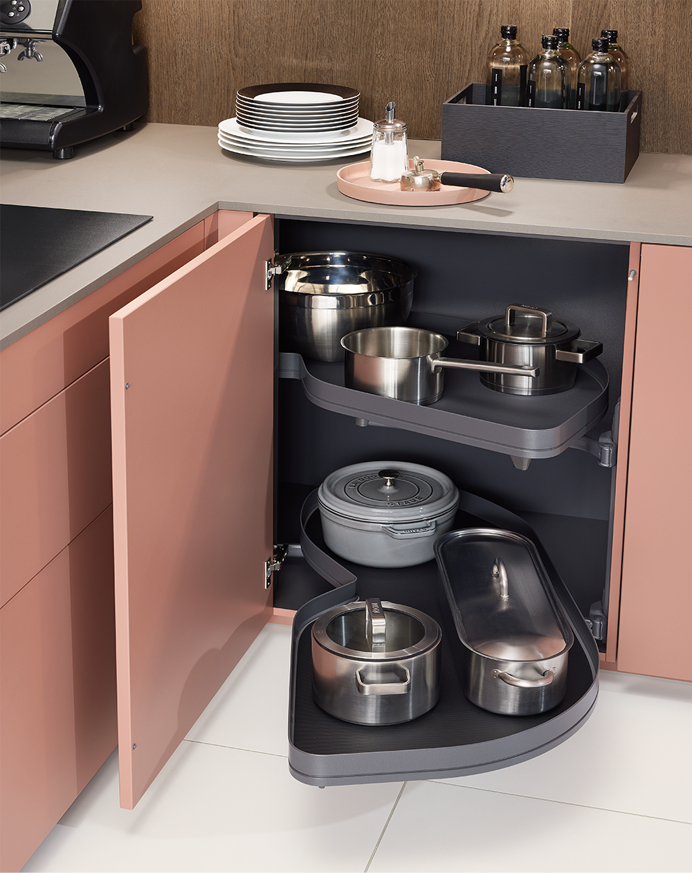Practical corner carousel in the pink kitchen by pronorm – smart storage solution for pots and kitchenware.