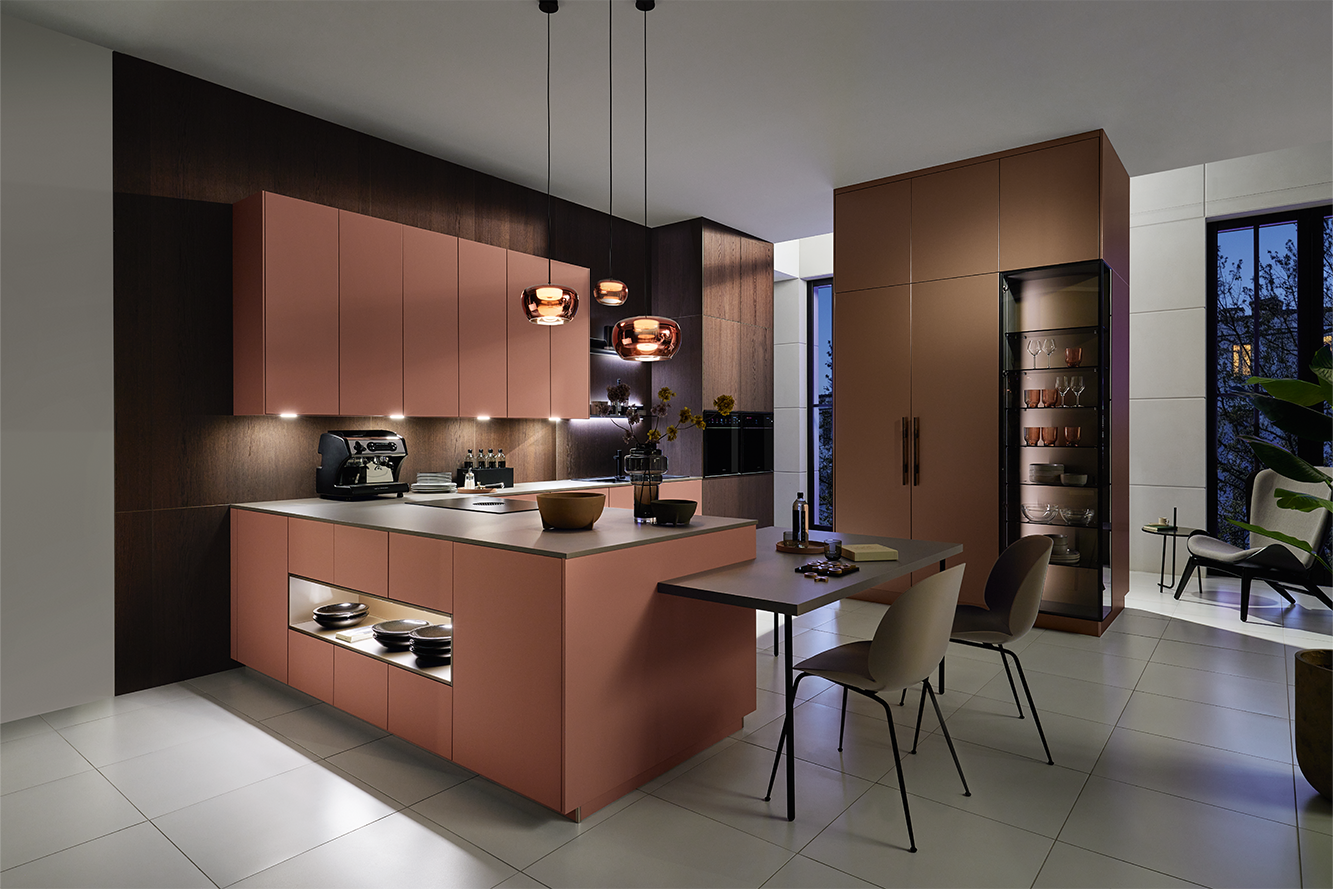 Moderne rosa Küche von pronorm mit eleganter Beleuchtung am Abend – stilvolles Design mit wohnlichem Ambiente.