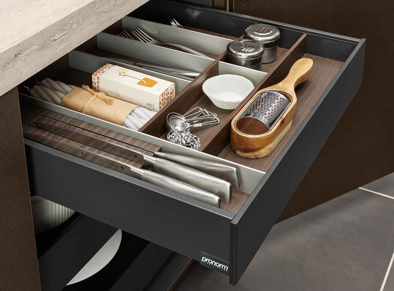 Organiseur à couverts haut de gamme dans un tiroir pronorm avec compartiments pour couteaux, épices et accessoires de pâtisserie – concept de rangement raffiné avec finition bois.