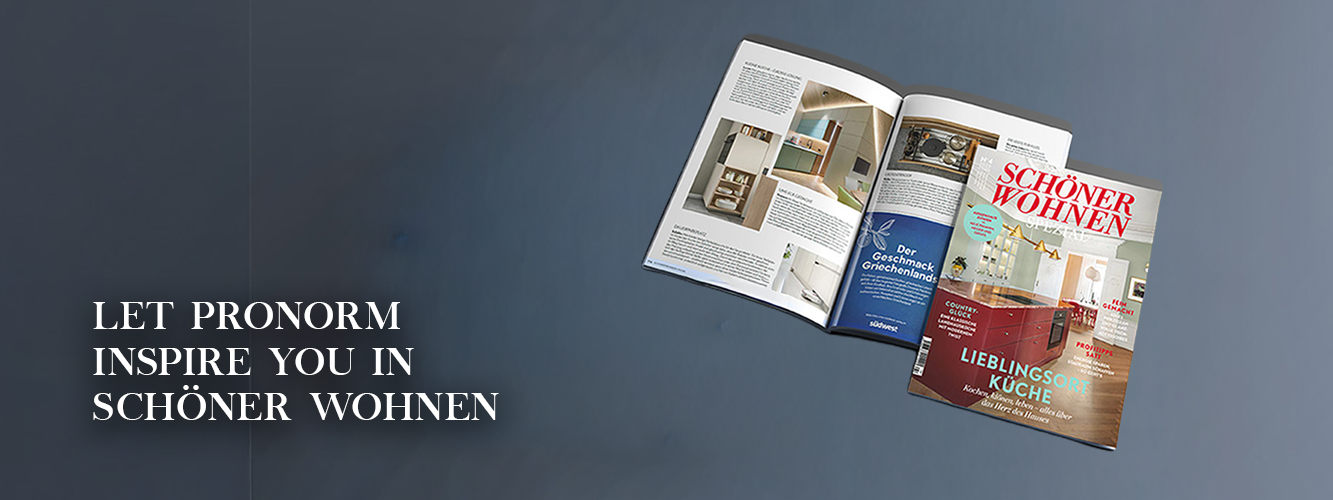 Open SCHÖNER WOHNEN interior design magazine on a grey background with the text Let pronorm inspire you to live more beautifully