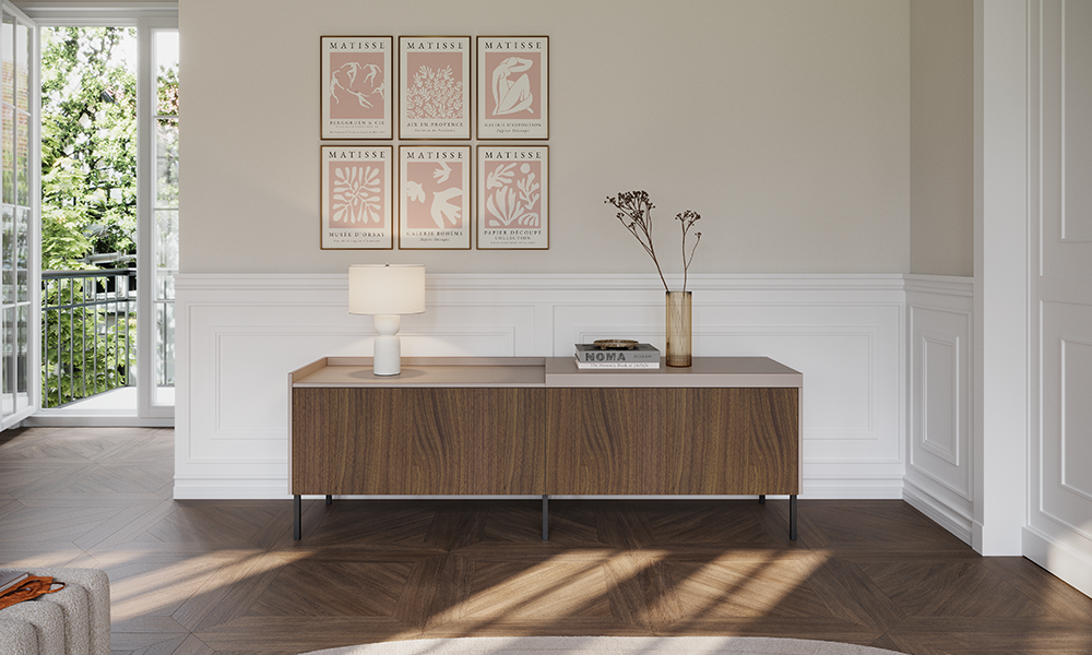 Buffet bas moderne en décor noyer avec pieds en métal noir dans un espace de vie élégant avec panneaux muraux blancs, œuvres de Matisse et beaucoup de lumière naturelle – meuble design pronorm.