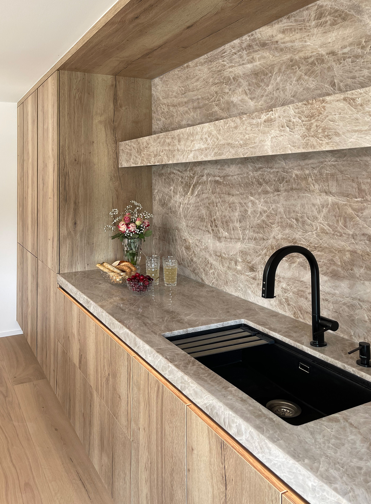 Keukennis met werkblad en achterwand van Taj Mahal natuursteen en fronten in Eik Marcato.