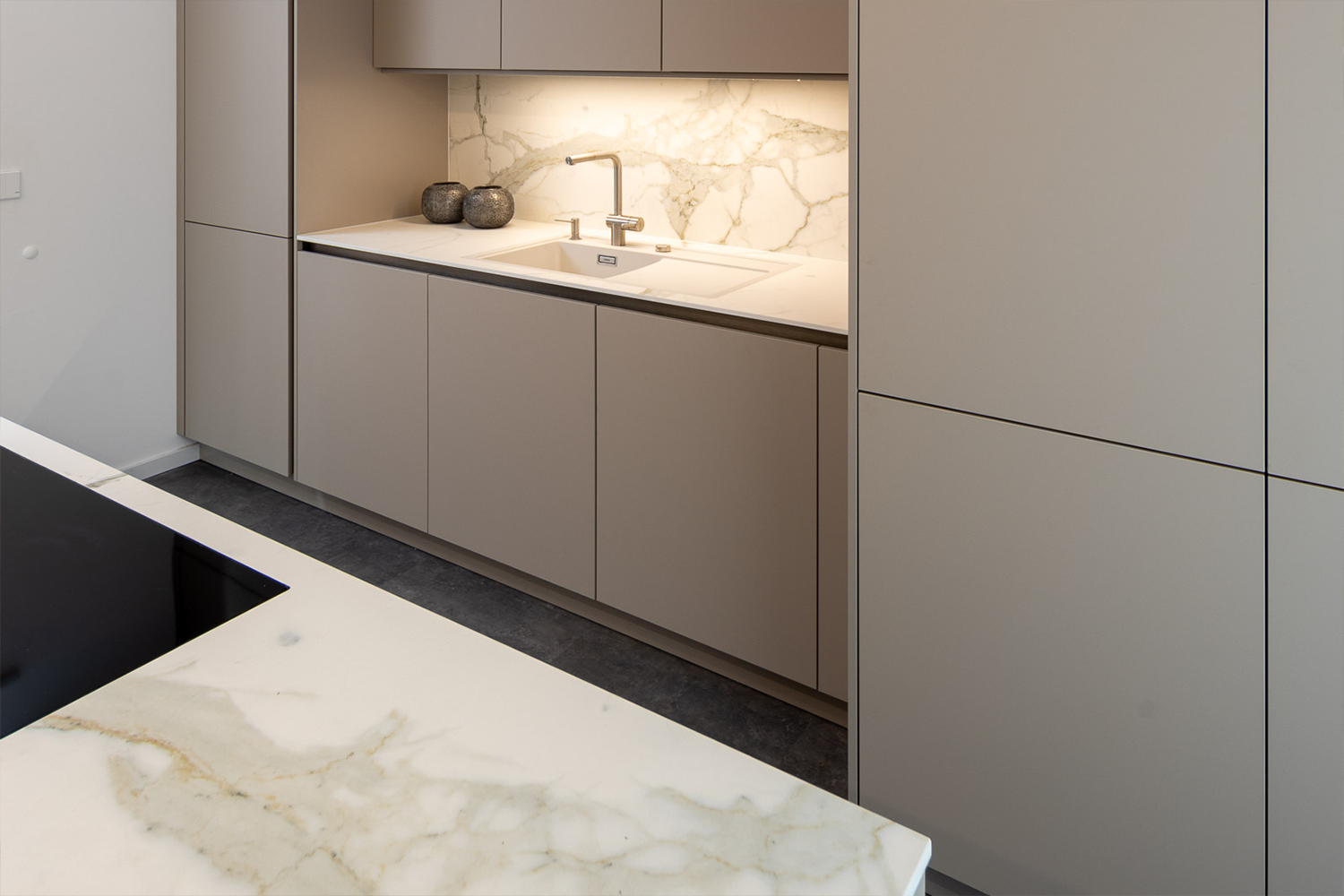 pronorm-modern-fitted-kitchen-illuminated-backsplash Beige pronorm design kitchen with handleless fronts and minimalist lines.