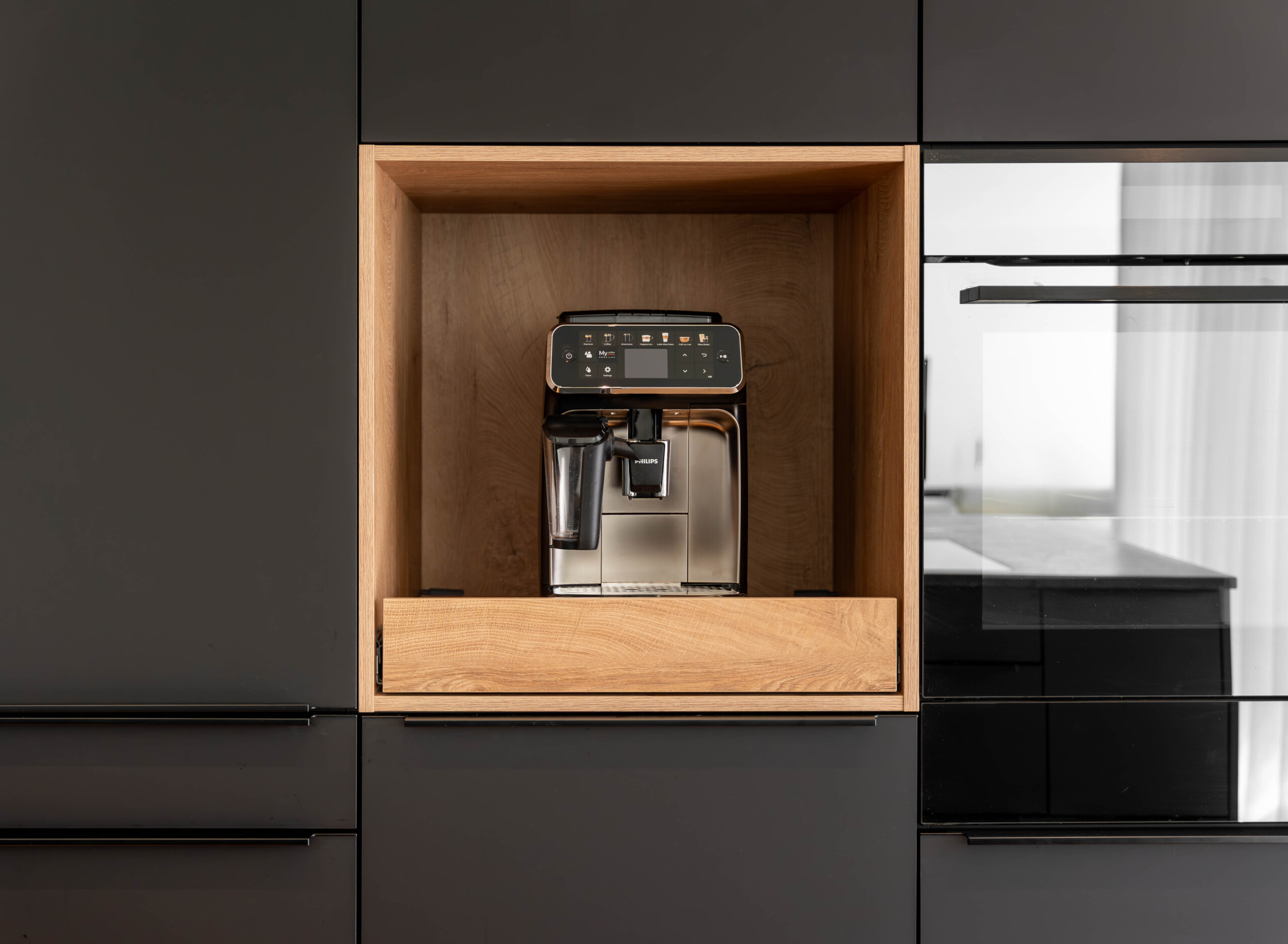 Moderne Designküche in Schwarz mit integrierter Barista-Kaffeeecke und praktischem Tablar-Auszug – stilvolle Lösungen für deinen Küchenalltag.