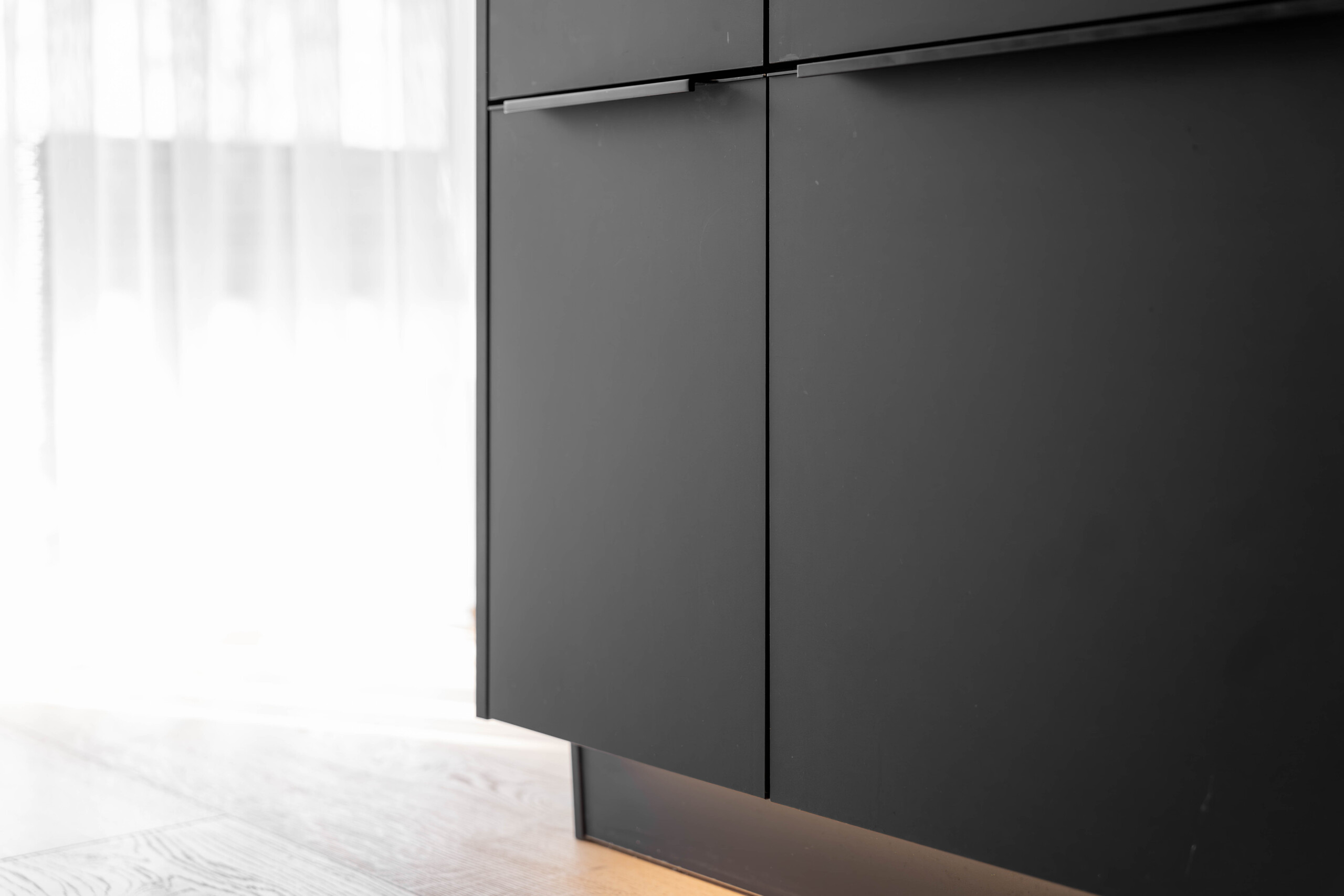 L’éclairage LED en plinthe met en valeur les façades noires et crée une ambiance lumineuse élégante dans ta cuisine.