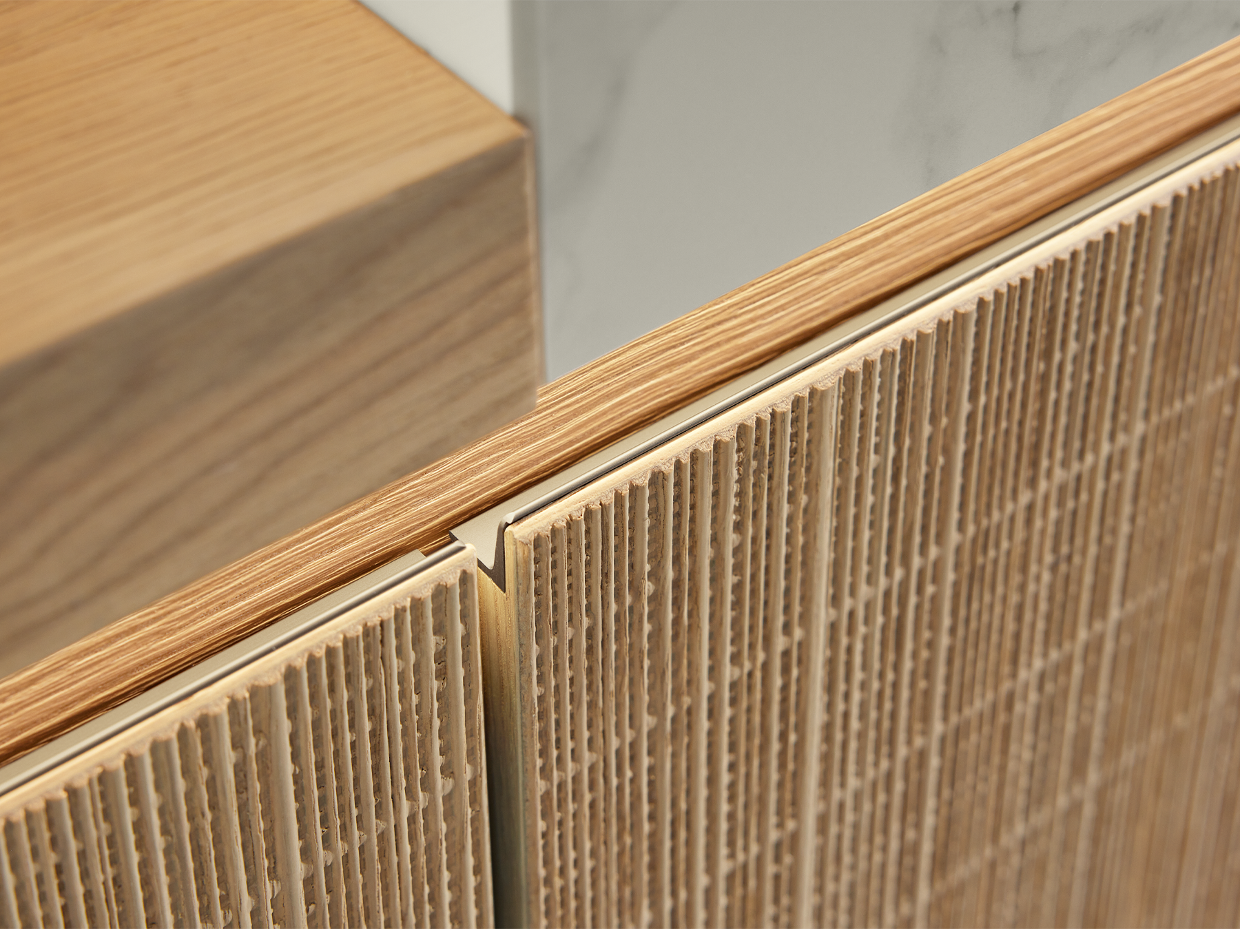 Keukenfront Boho Natur van pronorm met verticaal gestructureerd fineeroppervlak in lichte houtlook en geïntegreerde gouden greepuitsparing voor een natuurlijk en modern keukenontwerp.