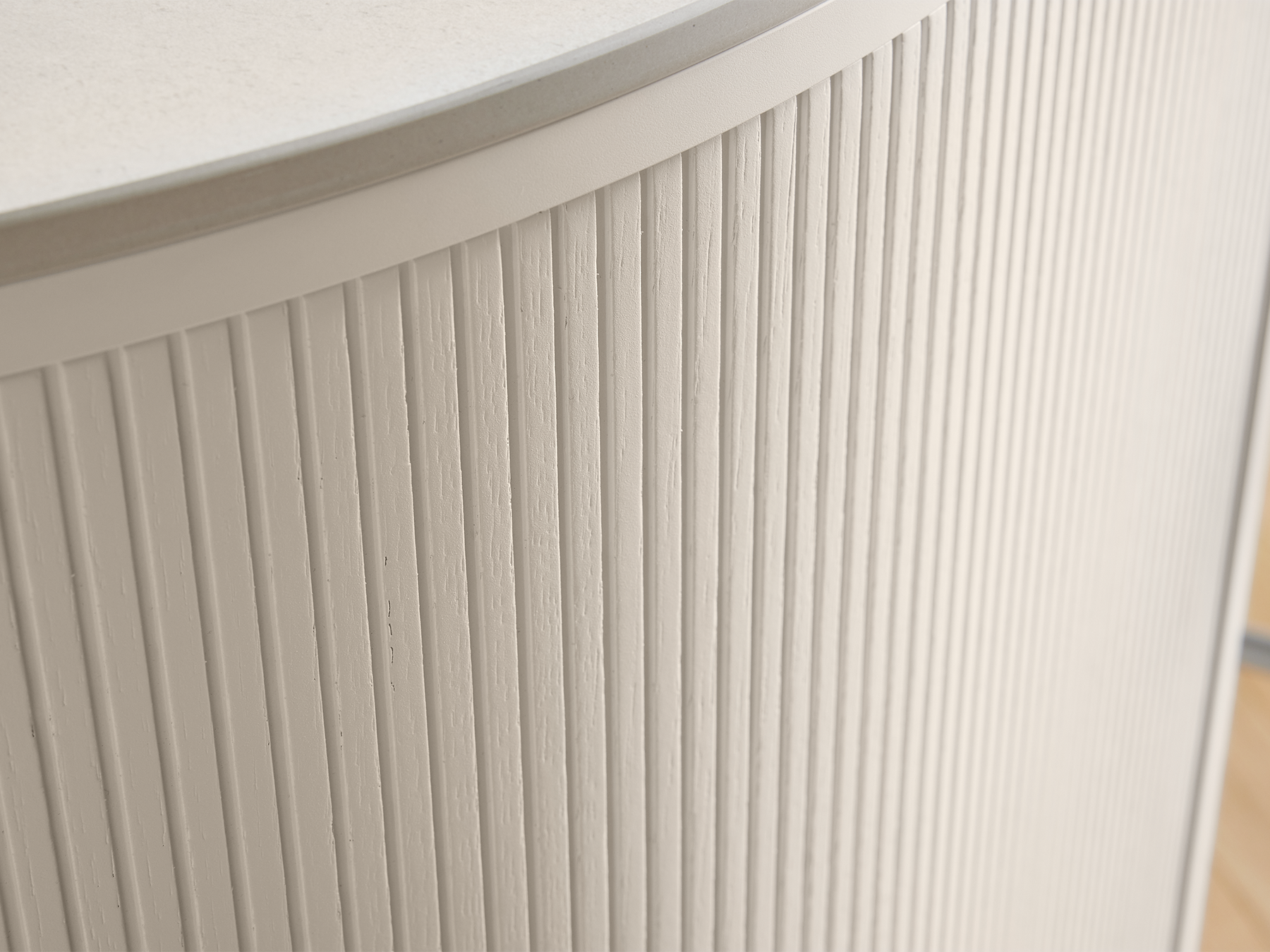 Detail view of a pronorm kitchen island in Angora grey with vertical ribbed look and matte lacquer surface – high-quality design with artisanal texture and natural character.