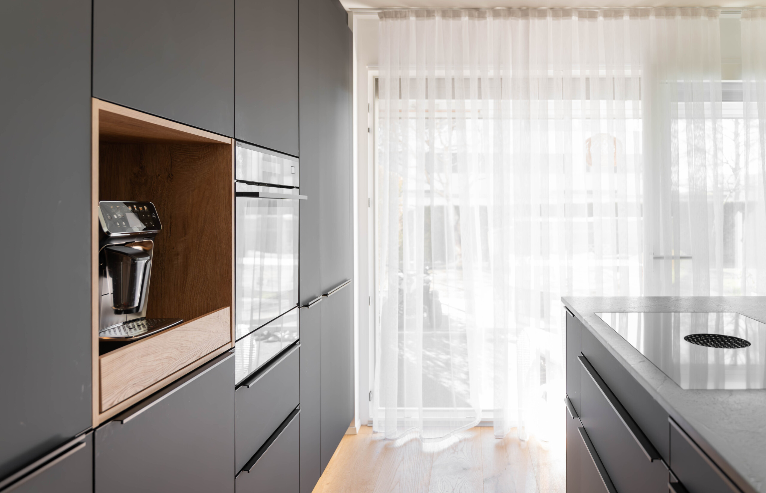 Lichtovergoten woonkeuken met strakke lijnen, hoogwaardige materialen en modern design – keuken en leefruimte perfect verenigd.