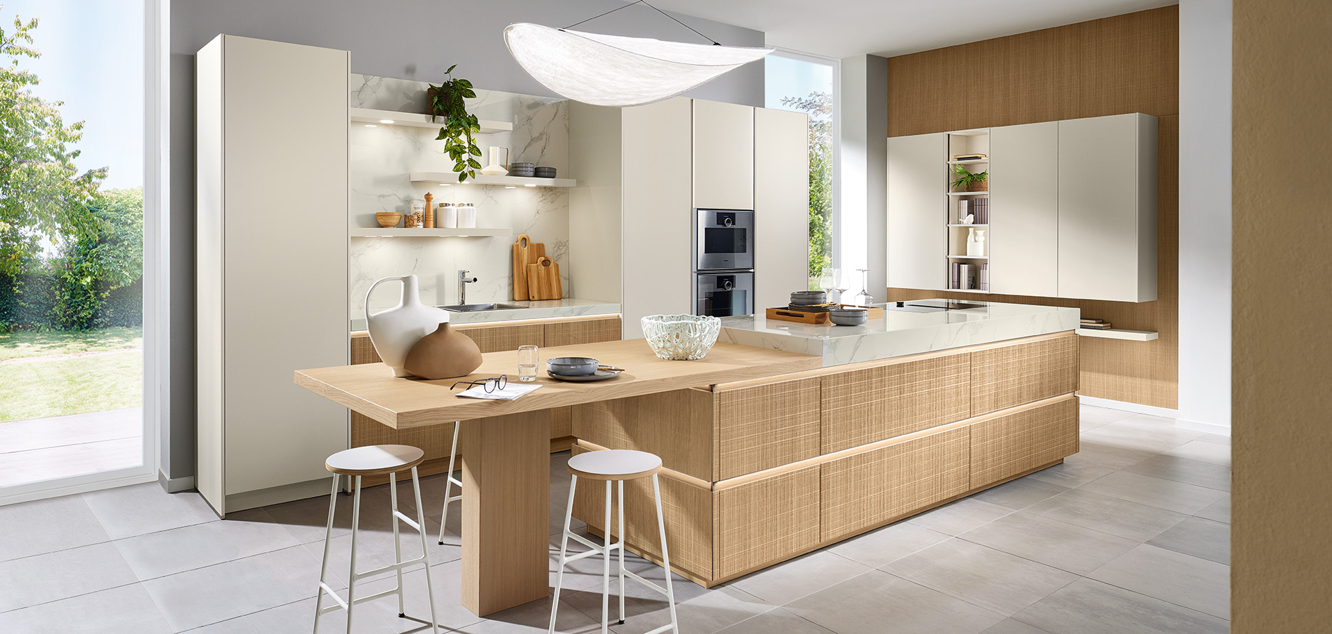 Boho-inspirierte Wohnküche mit Insel, Holzarbeitsplatte und strukturierter Front von pronorm in heller, natürlicher Gestaltung.