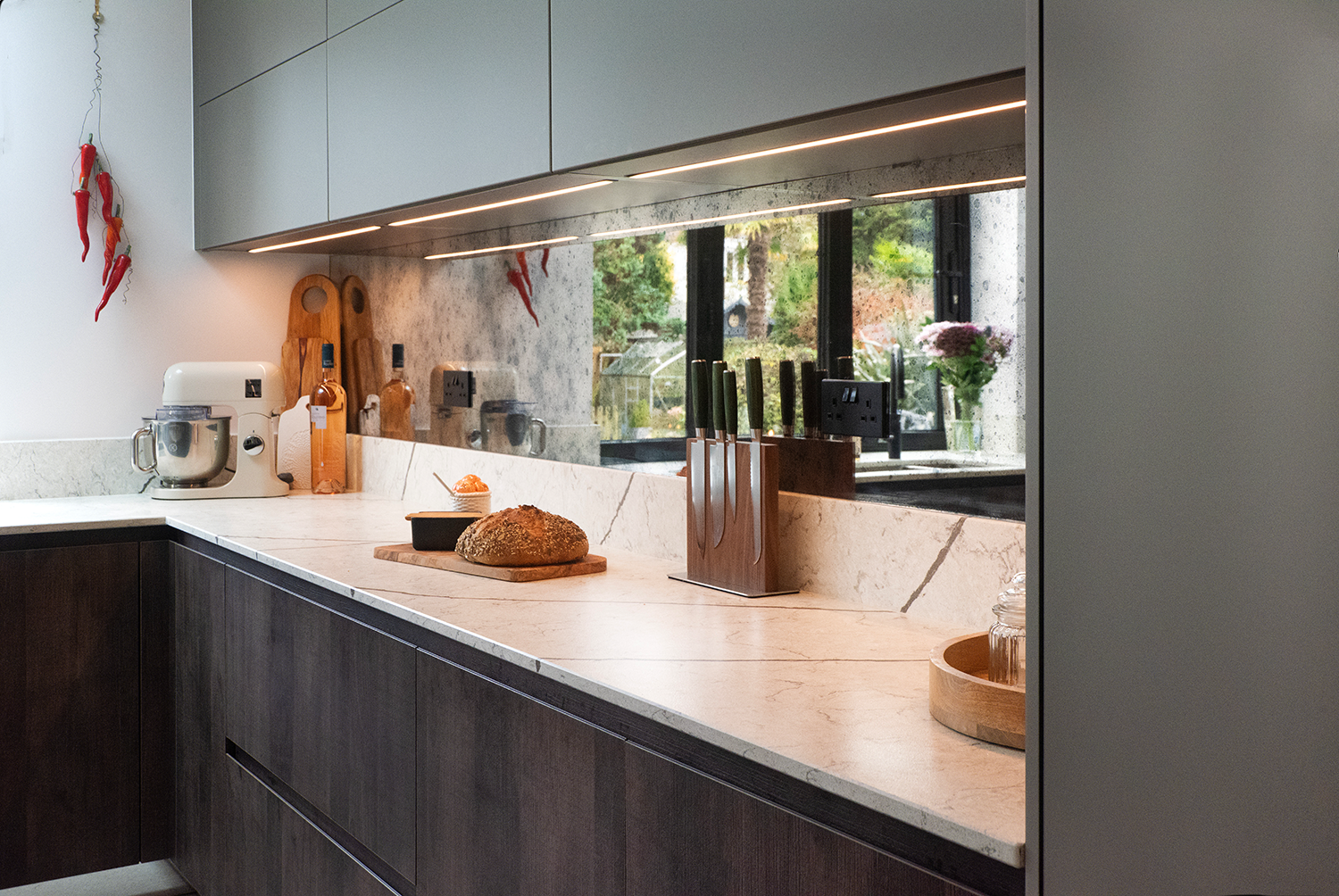 Cuisine pronorm minimaliste au style industriel avec plan de travail spacieux et crédence miroir.