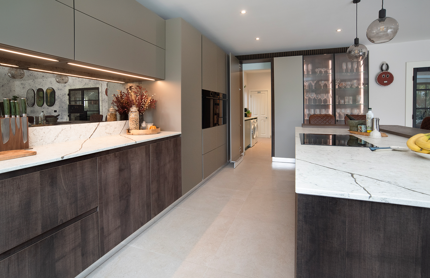 Cuisine pronorm minimaliste au style industriel avec vitrine en verre et buanderie intégrée.