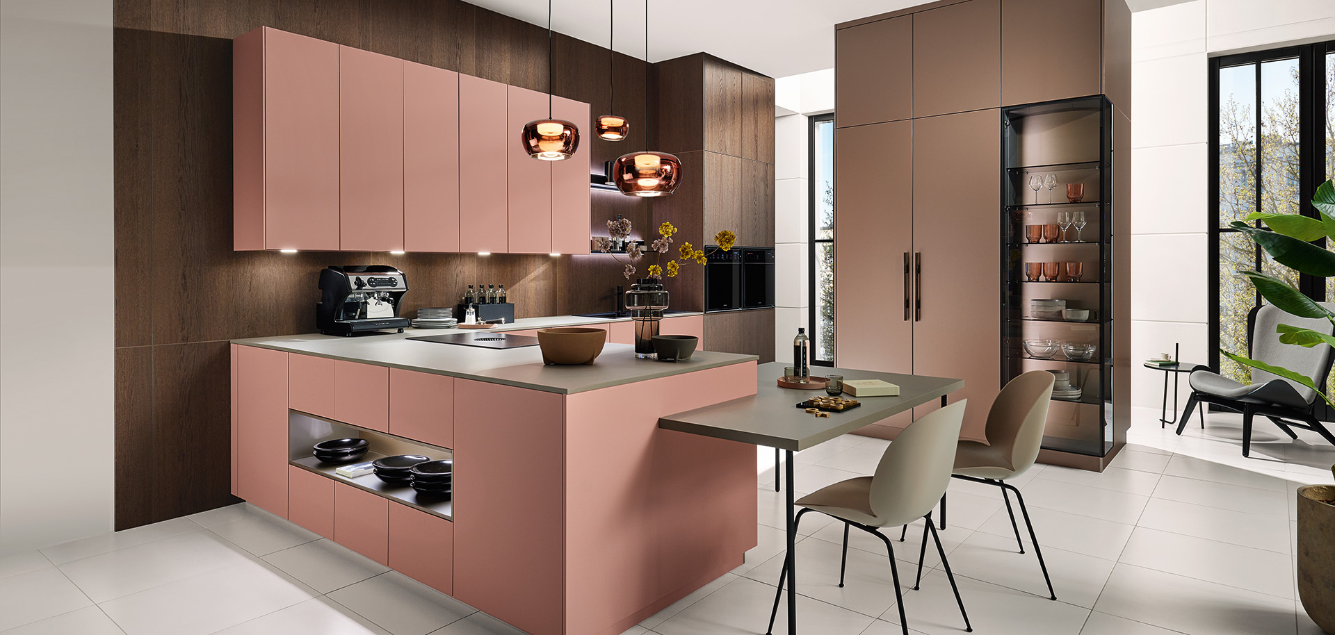 Farbige Designküche in Rosé mit Insel und integriertem Sitzplatz von pronorm in moderner Wohnumgebung.