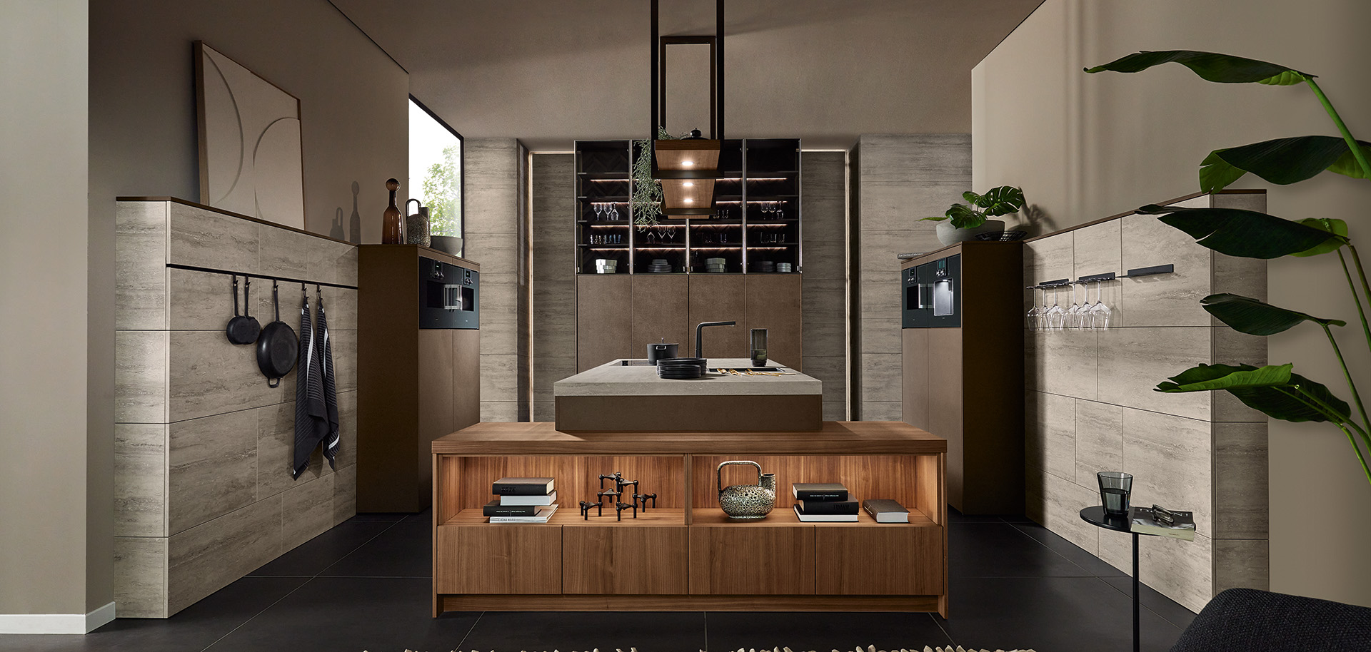 Grifflose Designküche mit Insel, Natursteinoptik und Nussbaum-Furnier von pronorm in dunkler, moderner Wohnumgebung.