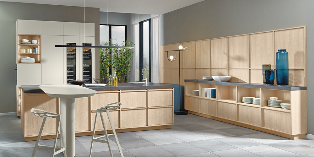 A bright pronorm kitchen in Japandi style with plenty of storage, a kitchen island and a matching sideboard with veneer fronts.