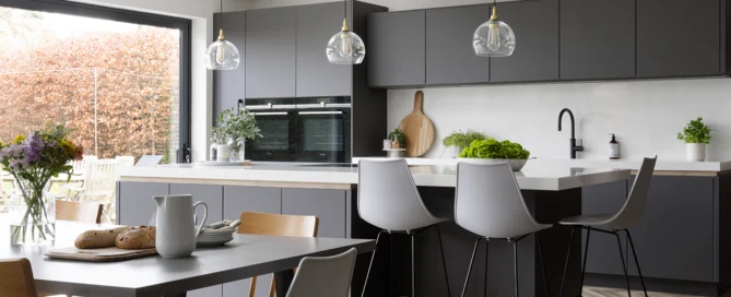 A dark grey pronorm kitchen, very high quality, with a kitchen island and seating area.