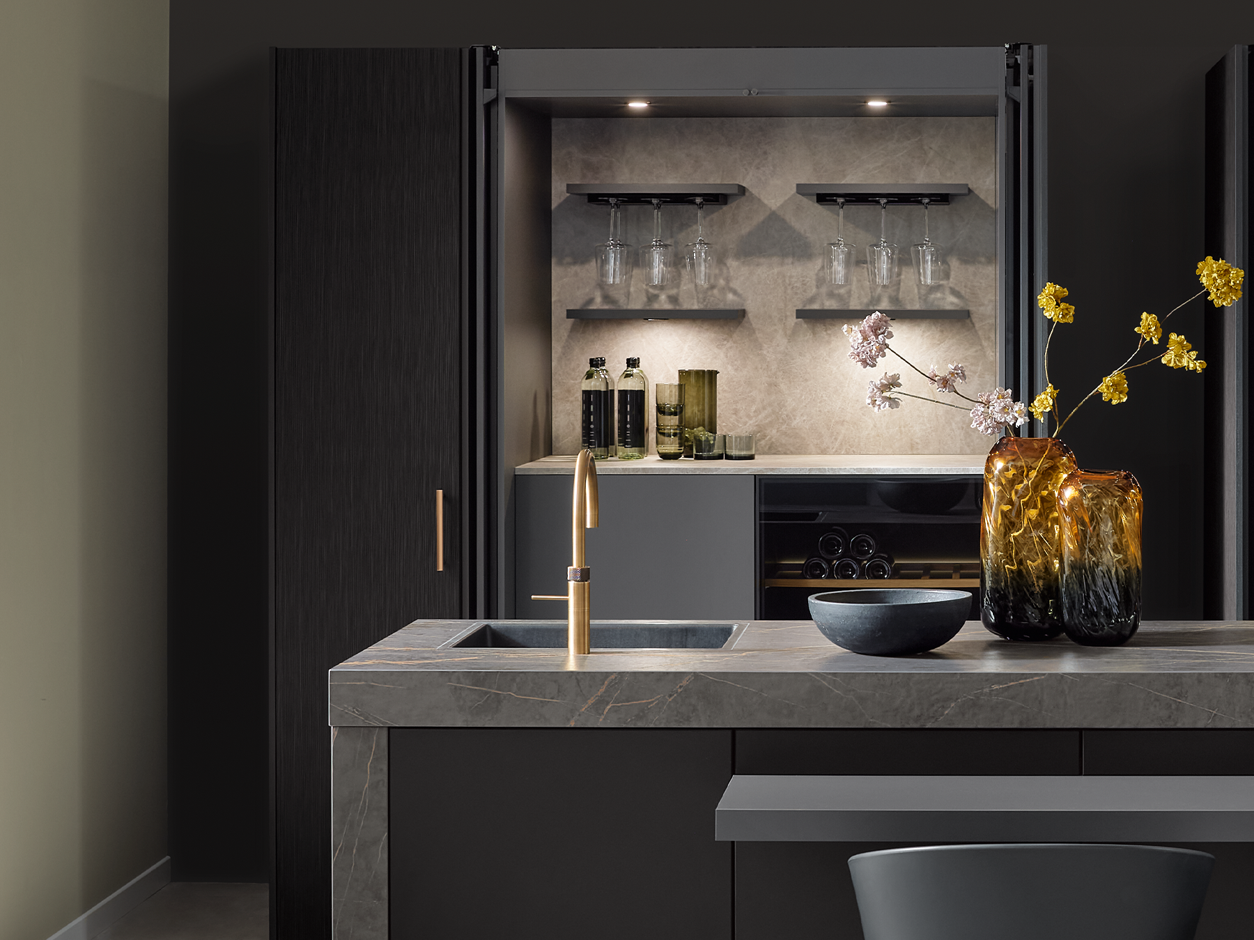 Hochschrank in einer hochwertigen pronorm Küche mit geöffneten Pocketdoors, die den Zugriff zu einer Bar öffnen.