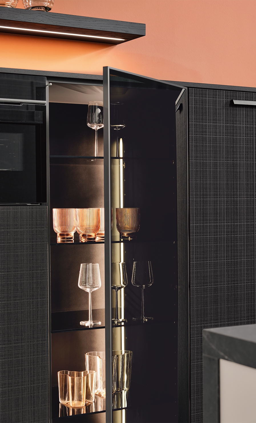 Pronorm Küche mit Hochschrank und einer Vitrine mit Glastür und Beleuchtung.