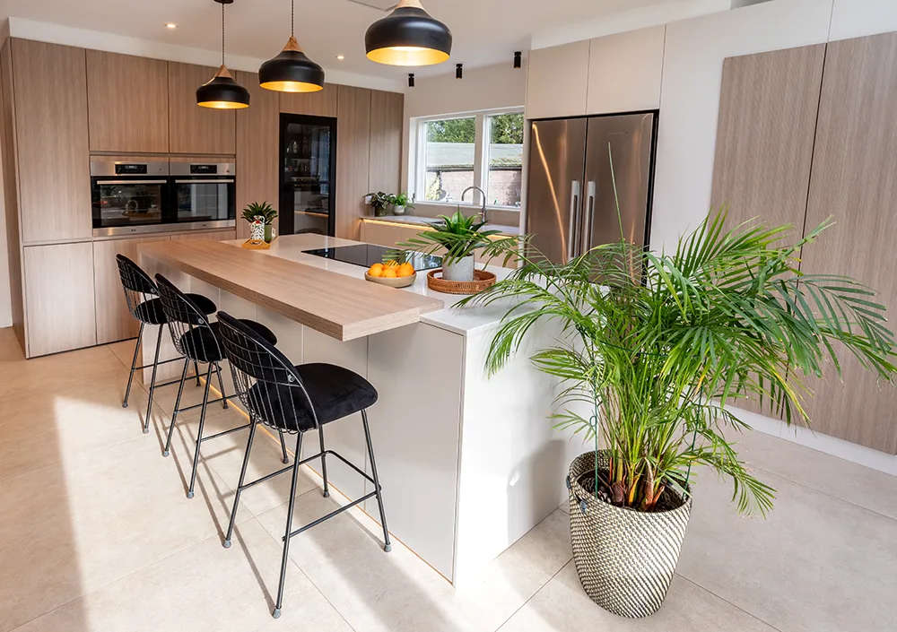 Cuisine scandinave lumineuse de pronorm avec îlot central et plante décorative.