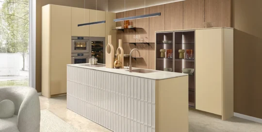 Cuisine pronorm avec îlot et joues arrondies dans des tons beige doux.