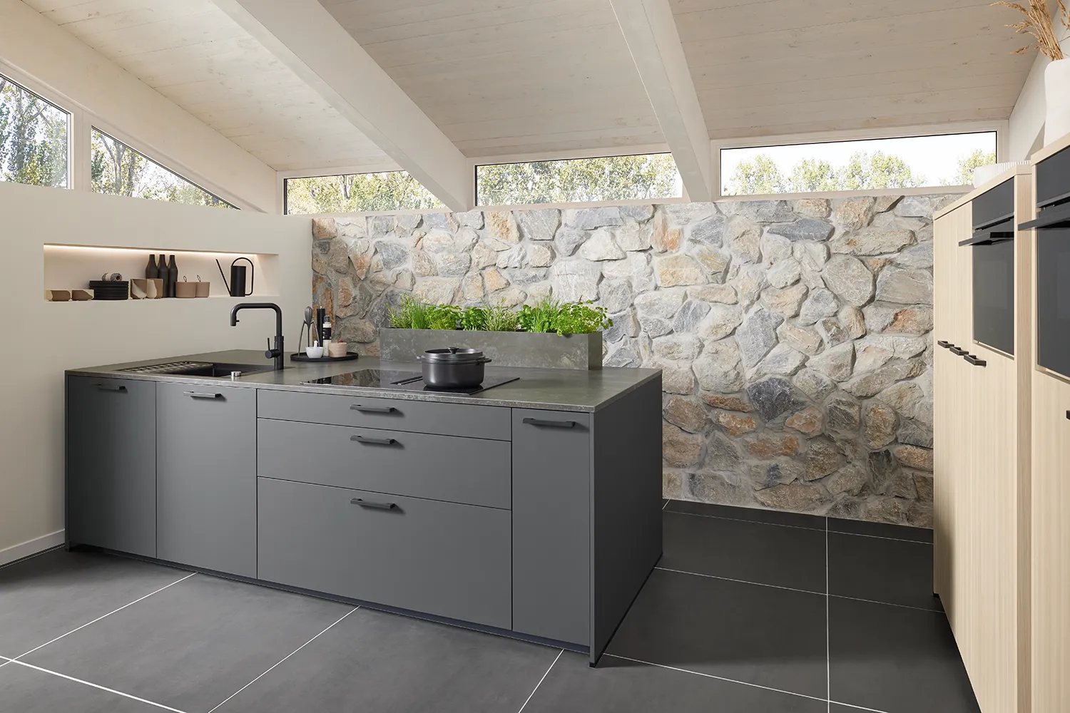 Grey Pronorm kitchen with ample storage for small spaces and warm wood elements.