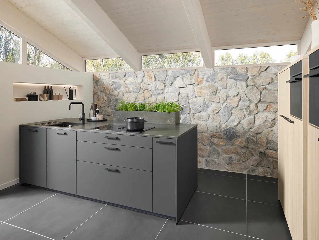 Grey Pronorm kitchen with ample storage for small spaces and warm wood elements.